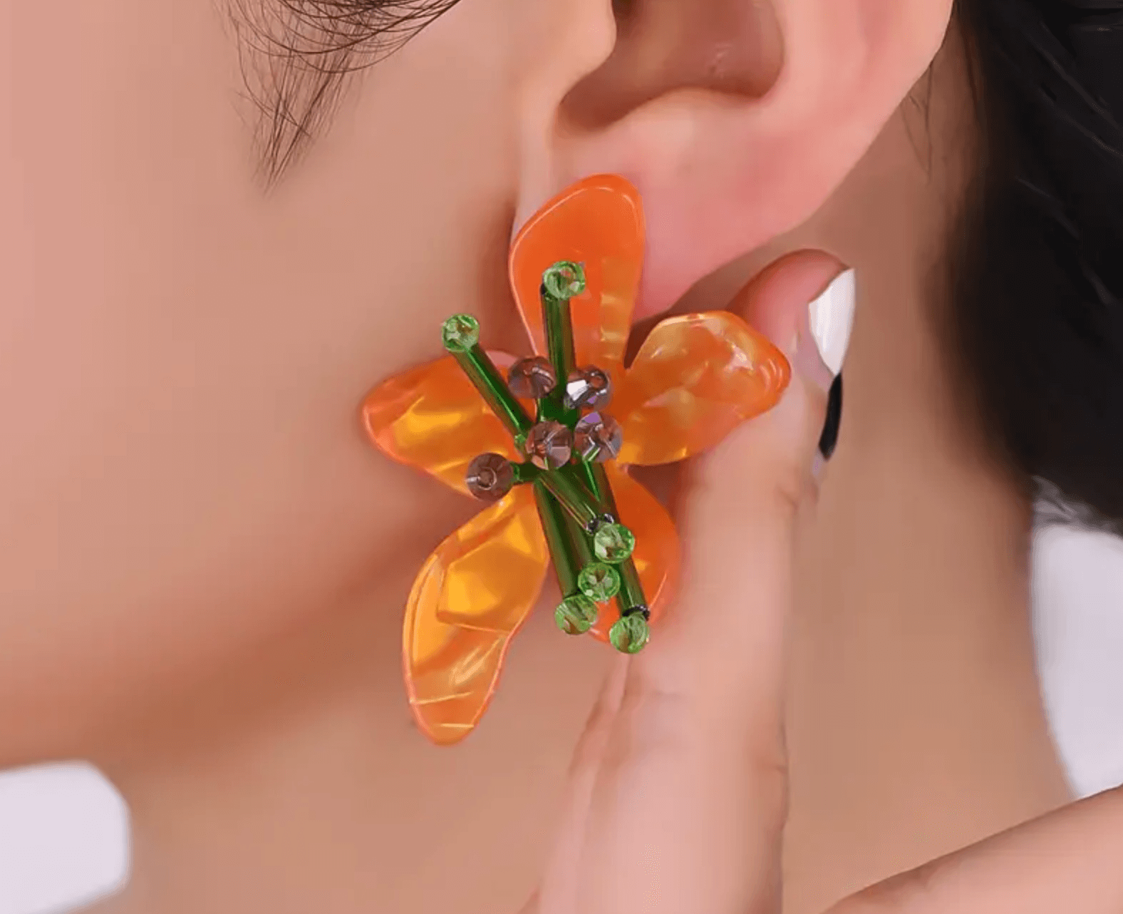Citrus Petal Drops earrings with vibrant citrus-colored flower petals, worn by a model.